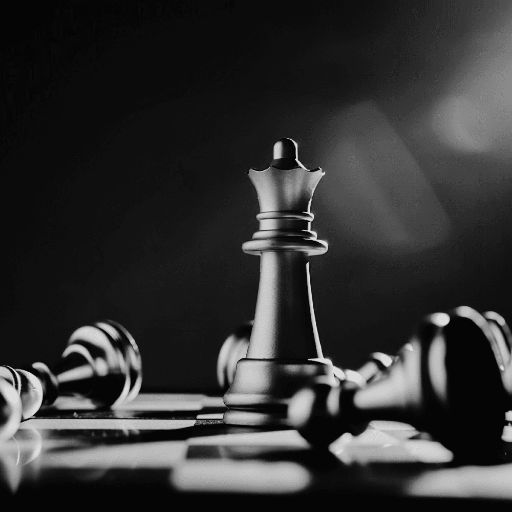 Black and white chess queen piece standing among fallen pieces